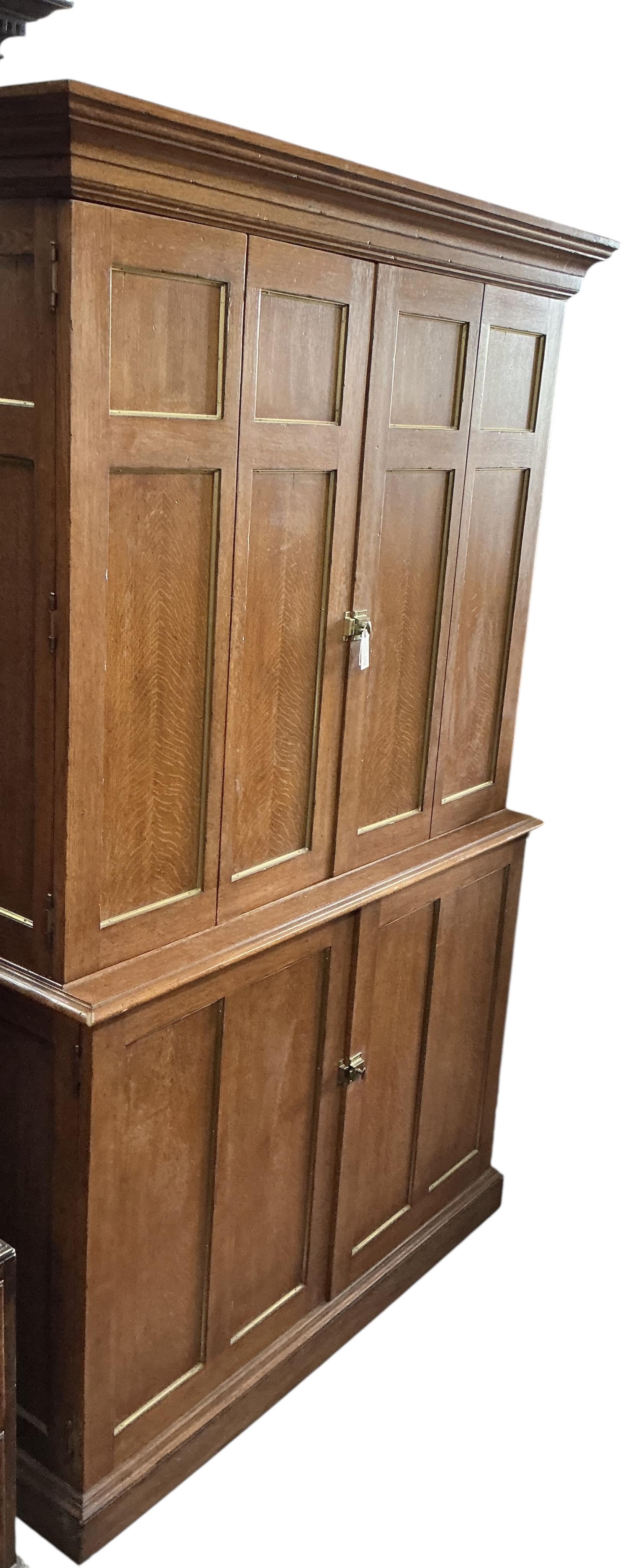 A brass mounted oak media cabinet, retailed by Ralph Lauren, upper section with bi-fold doors, width 140cm, depth 53cm, height 225cm